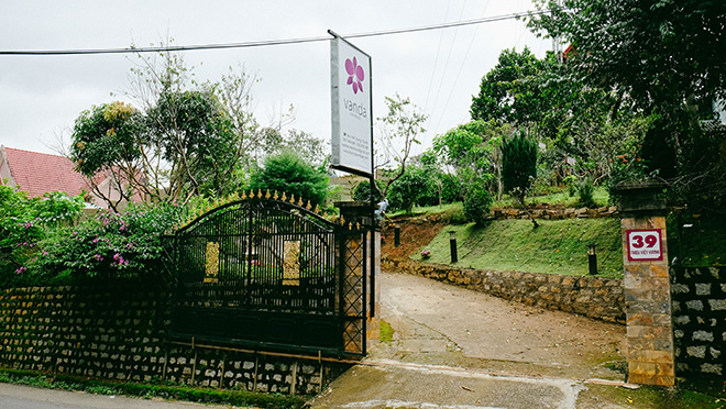 Vanda Dalat với chiếc cổng đen rộng lớn chào đón, nhìn từ bên ngoài bạn có thể tưởng tượng ra bên trong chính là một khu vườn tươi mát với cây xanh bao phủ.
