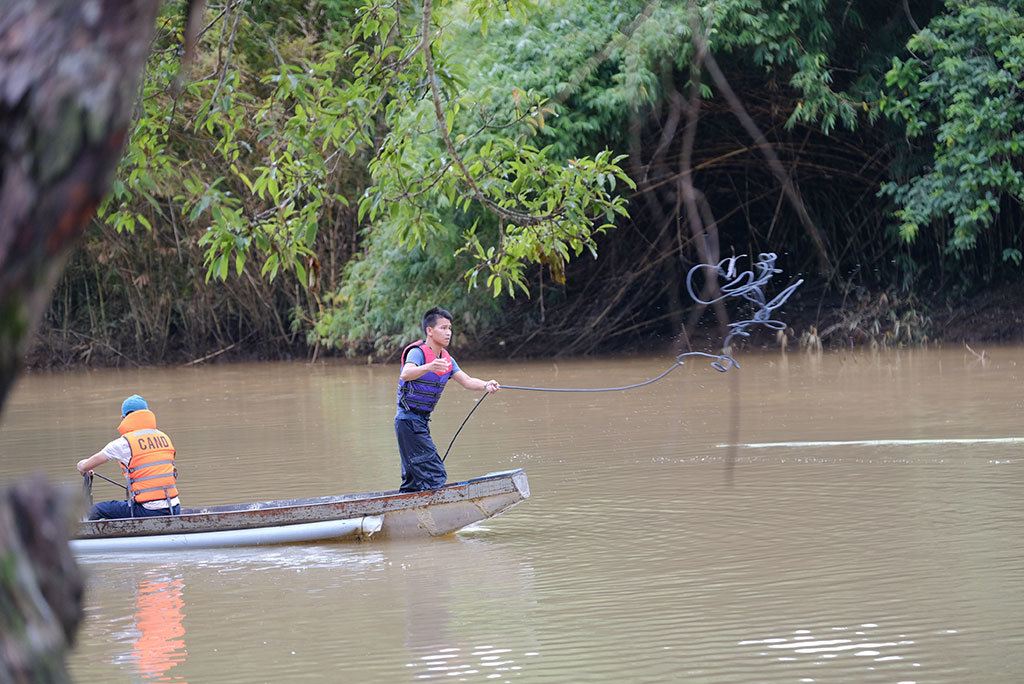 Lực lượng cứu hộ tìm kiếm nạn nhân trên đoạn sông xảy ra vụ lật xuồng - Ảnh: M.VINH